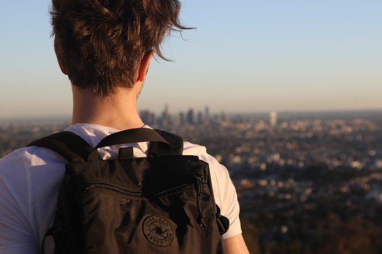 man with rucksack looking over LA scenery